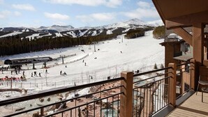 A ski resort with a ski lift, snow-covered slopes, and a view of mountains. - Ski In/Ski Out Master at Grand Lodge on Peak 7 (Breckenridge)