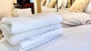 Een hotelkamer met een bed, een spiegel en een keurig opgevouwen stap handdoeken.