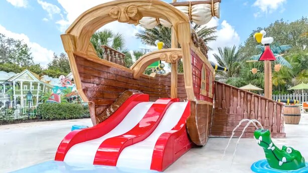Een waterpretplaats met piratenthema, inclusief een glijbaan en een waterattractie in de vorm van een krokodil.
