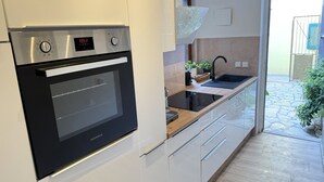 Ett modernt kök med en inbyggd ugn, en diskho och en bänkskiva.