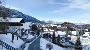 A snow-covered village with buildings, a road, and mountains in the background. - Holiday Home With Panoramic Views (Tulfes)