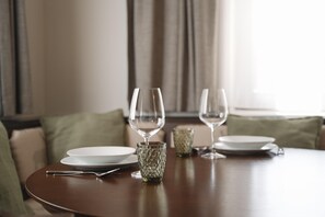 A dining table with two white plates, a glass, and a cutlery set. - Alpenchalet Berggold - Holiday Home With Panoramic Views (Tulfes)