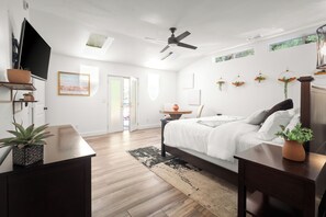 A bedroom with a bed, a ceiling fan, a TV, and a window. - Modern Fully Remodeled 3 Bedroom Gem with a Hot Tub and Close to Everything (Sedona)
