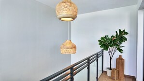 Eine Treppe mit Glastrennwand und zwei gewebten Pendelleuchten.