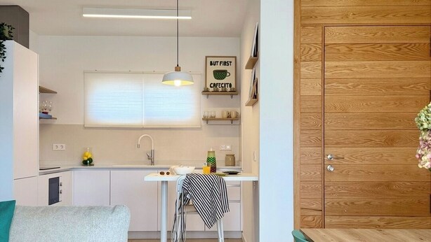 Una cocina moderna con zona de comedor, un sofá y un armario de madera.