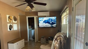 A living room with a TV, a ceiling fan, and a view of a mountain through the window. - Enjoyable 2-bedroom house with AC in Green Valley, Nice covered patio. (Green Valley)