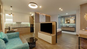 A modern living room with a flat-screen TV, a sofa, and a coffee table. - BayGi Phu Quoc Hotel (Phu Quoc)