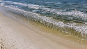 Una playa con aguas azul cristalino y una orilla arenosa.