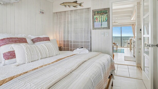 Un dormitorio con una cama grande, un pez montado en la pared y vistas al balcón.