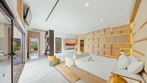 A modern living room with a large sofa, a TV mounted on the wall, and a wooden accent wall. - NEW LUX 5 Bed 5 Bath Pool Near To Beach By Bocobay (Noord)