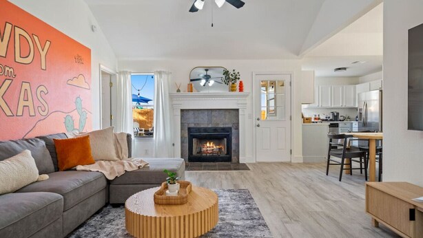 A modern living room with a fireplace, a dining area, and a kitchen. - Texas Getaway w/ Fire Pit, Grill & Ping-Pong (Leander)