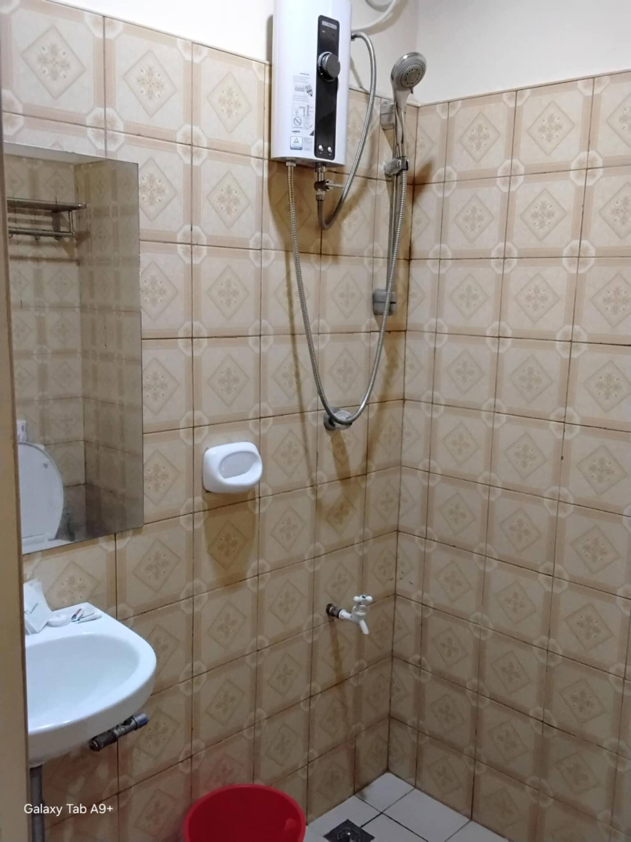 A small bathroom with a toilet, sink, and shower.