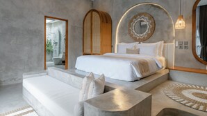 Un dormitorio moderno con cama, sofá, espejo y una lámpara circular.