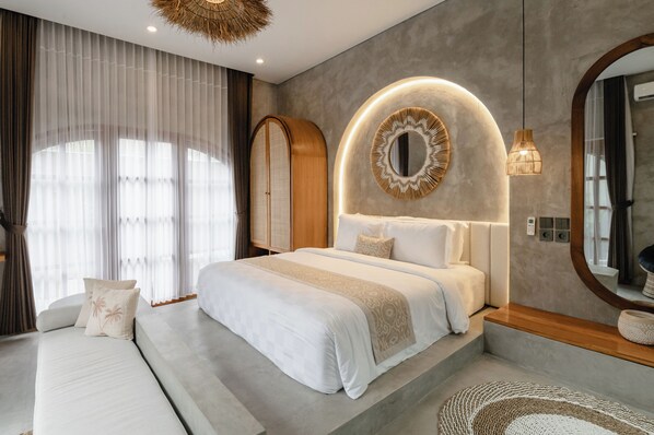 Un dormitorio moderno con una cama grande, un sofá, un espejo y una lámpara en el techo.