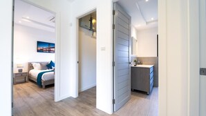 Una camera d'albergo moderna con un letto, comodino e vista sulla città.