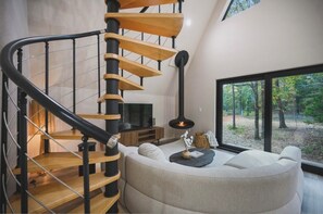Ein modernes Interieur mit einer Wendeltreppe, einer gemütlichen Sitzecke und einem Kamin.