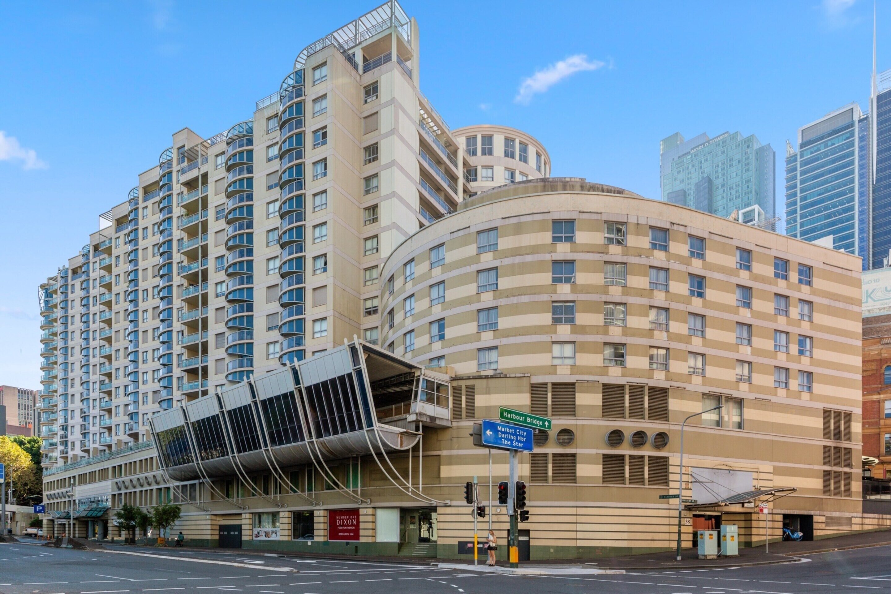 A high-rise hotel with a curved facade, multiple balconies, and a prominent entrance with a glass canopy. - Bright & Spacious 1-bed in Vibrant Sydney (Sydney)