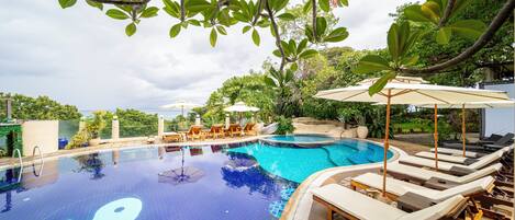 Alberca al aire libre, sombrillas en la alberca y camastros