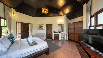 A hotel room with a large bed, a desk, a television, and a wardrobe.