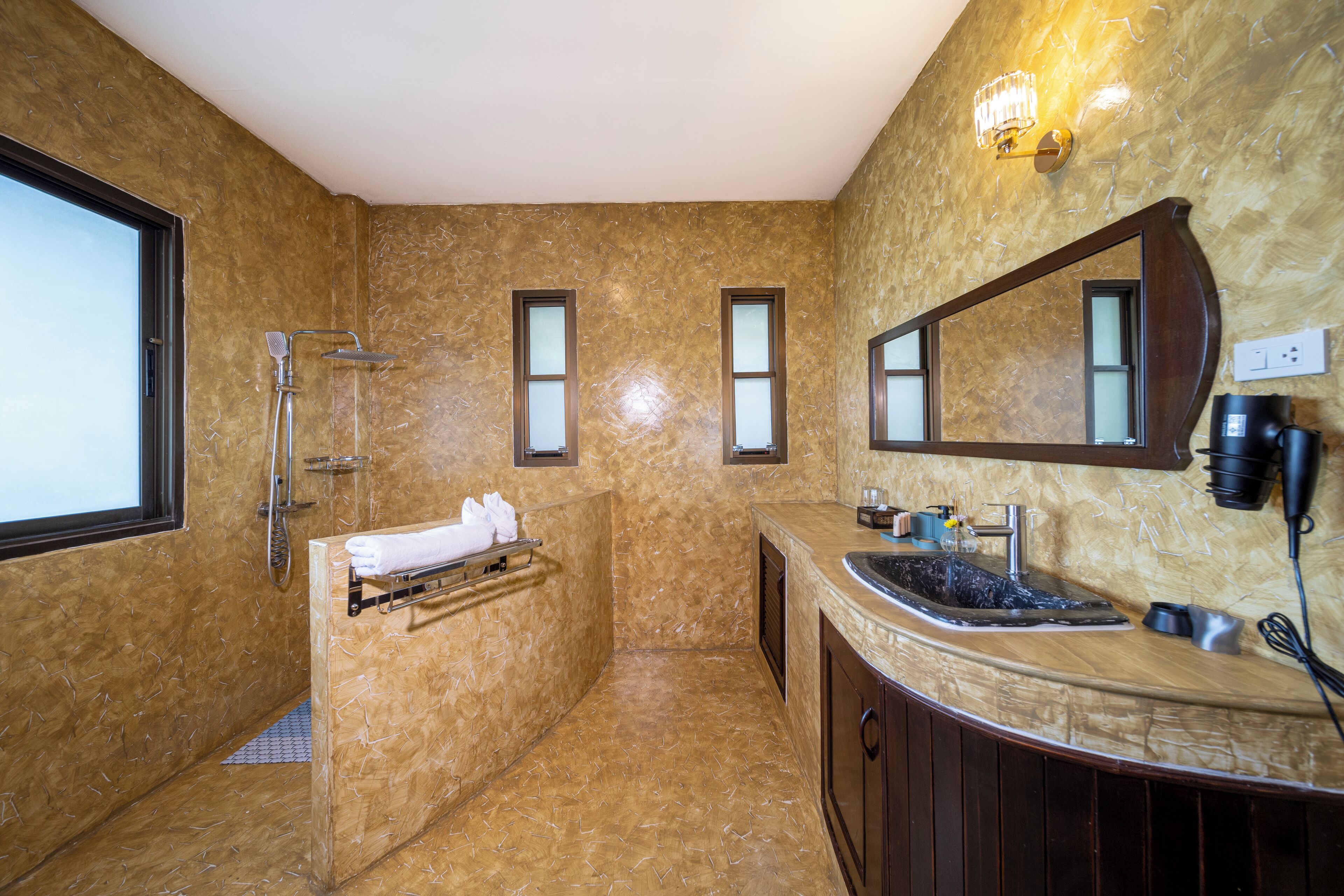 Een badkamer met een grote spiegel, een wastafel en een douche.