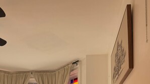 A neatly made bed with a brown pillow, a bedside lamp, and a framed picture on the wall. - Bright & Spacious Home close to NYC and World Cup (Bayonne)