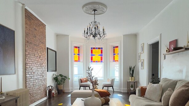 A living room with a fireplace, a chandelier, and a large window with stained glass. - Bright & Spacious Home close to NYC and World Cup (Bayonne)