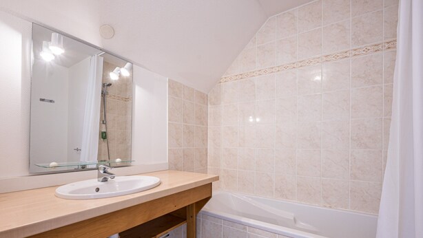 A bathroom with a sink, mirror, and bathtub. - Birdie F Ndeg21 - 5p10 (Giez)