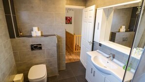 A modern bathroom with a toilet, sink, and mirror. - Leamington Spa House with 4 Bedrooms (Leamington Spa)