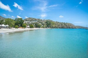 A coastal resort with clear turquoise waters, a sandy beach, and a hillside with buildings. - Villa Ti Punch - Tropical villa with a private pool (Les Trois-Îlets)