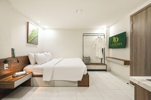 Ein modernes Hotelzimmer mit Bett, Nachttisch und Spiegel. An der Wand ist ein grünes Schild mit "La Doma" zu sehen.