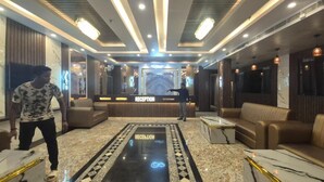 A reception area with a reception desk, a black and white patterned carpet, and a reception sign. - HOTEL SEA SOUL AYAN GROUP OF HOTEL  (Digha)