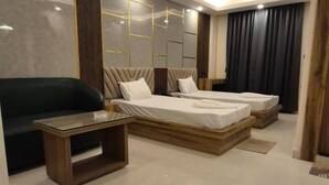 A modern bedroom with a large bed, a sofa, and a coffee table. - HOTEL SEA SOUL AYAN GROUP OF HOTEL  (Digha)