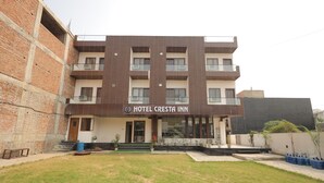A hotel named 'Hotel Cresta Inn' with a modern design, featuring a flat roof, multiple balconies, and a well-maintained lawn in front. - HOTEL CRESTA INN (Agra)