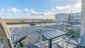 Ein Balkon mit Blick auf einen Parkplatz und Gebäude.