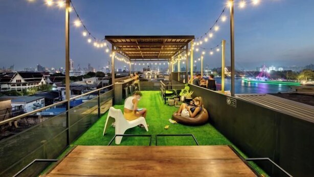 A rooftop terrace with string lights, seating areas, and a view of the cityscape. - Ralph Bangkok (Bangkok)