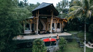 A wooden house with a balcony, surrounded by lush greenery. - Camaya Bali (Selat)