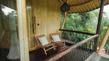 A bamboo room with two wicker chairs and a small table.