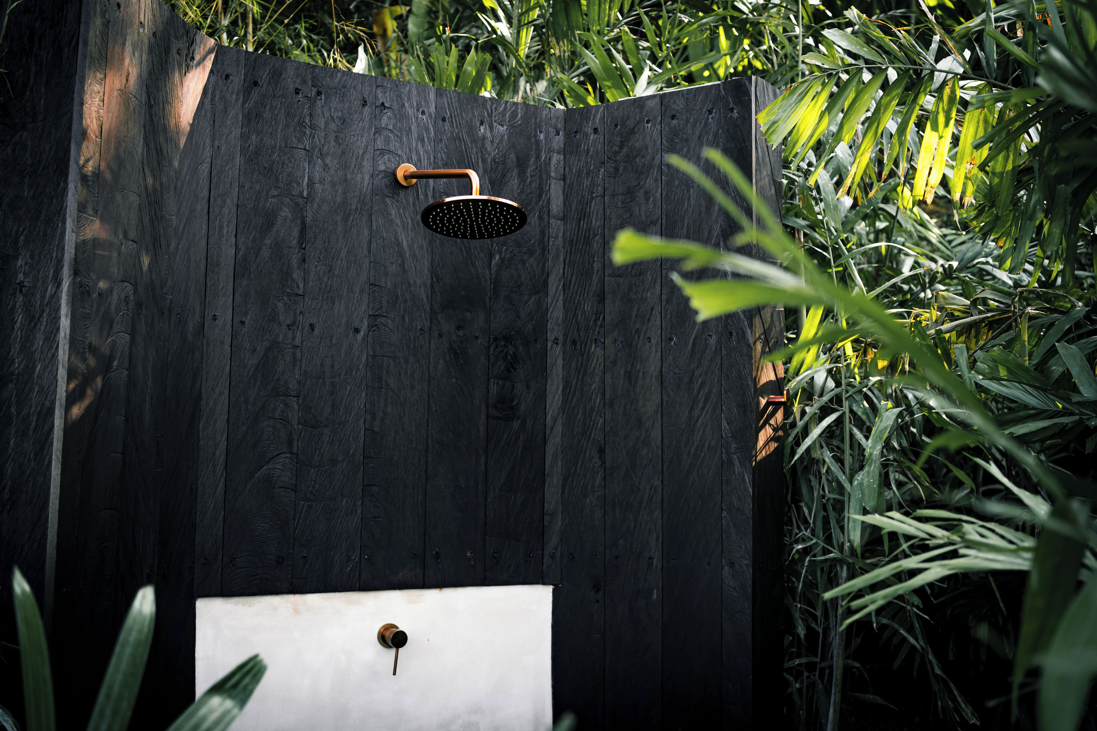 A wooden fence with a built-in showerhead and sink.