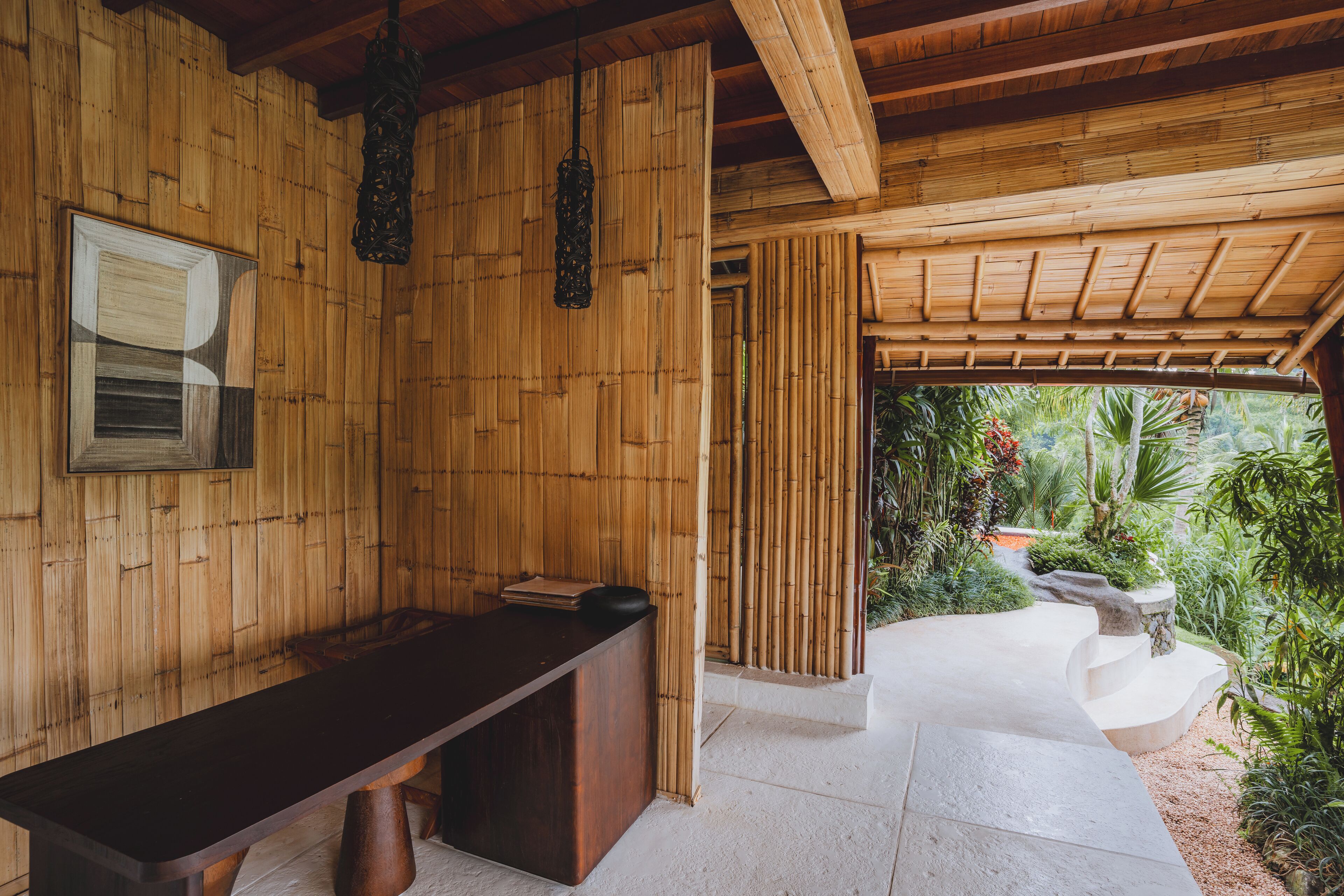 A reception area with a wooden reception desk, a framed certificate, and a hanging light fixture.