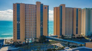 Ein hoch aufragendes Hotel mit mehreren Etagen, einer Glasfassade und Blick auf den Ozean.