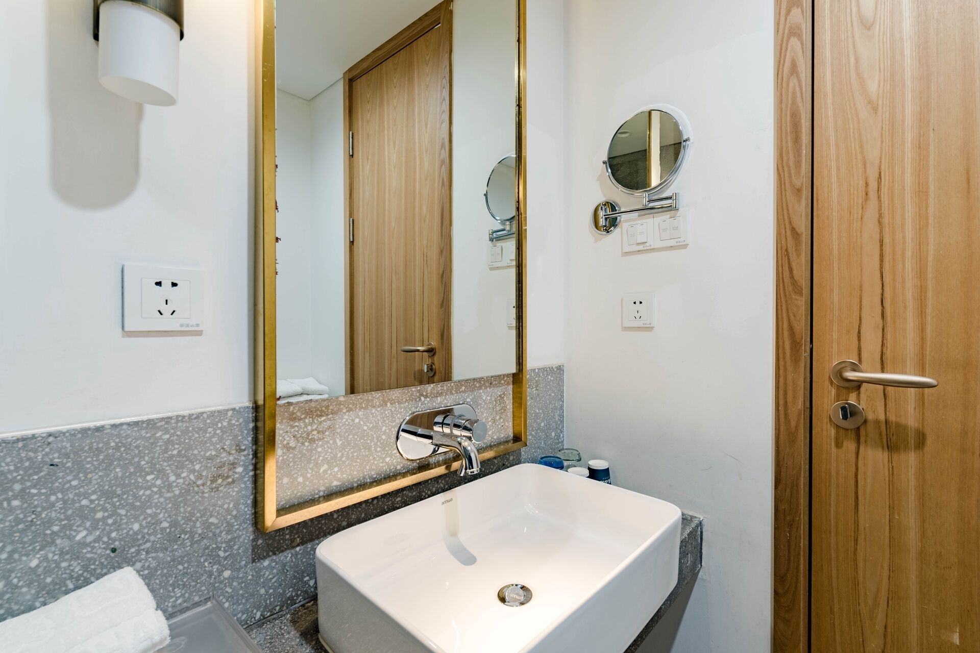 A bathroom with a white sink, a mirror, and wooden doors.