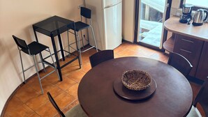 Une cuisine compacte équipée d’un réfrigérateur, d’une machine à café et d’une fenêtre donnant sur un paysage agréable.