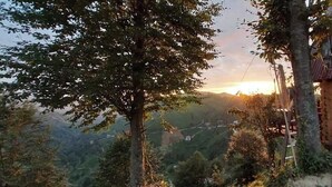 Una cabaña de madera con vistas a un valle y montañas.