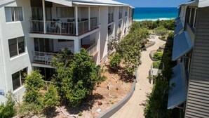 Un edificio de varios pisos con balcones que dan a la playa.
