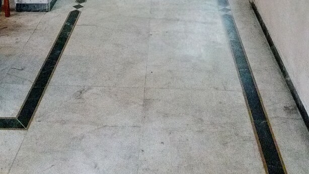 A long, narrow hallway with marble flooring and columns, leading to multiple doors. - Rajshree Hotel (Ahmedabad)