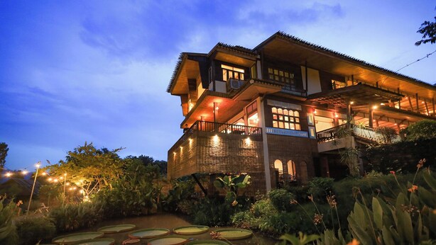 A multi-story building with a traditional architectural style, featuring balconies and a well-lit exterior.