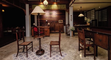 Un interior de madera tradicional con una mesa central, sillas y una lámpara.