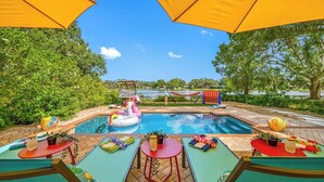 A pool area with a floating unicorn, lounge chairs, and a hammock. - Lakehouse Escape|Pool|HotTub|Game Suite|Sleeps 20 (Tampa)