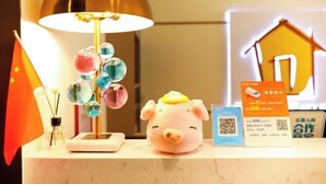 Ein Schreibtisch mit einer Lampe, einem Schwein-förmigen Gegenstand, einer Flagge und einigen Karten.