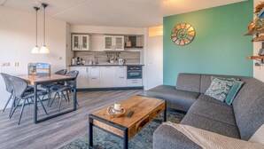 A modern apartment with a dining area, kitchen, and living room. - Nice Apartment Near the Center of De Koog (De Koog)